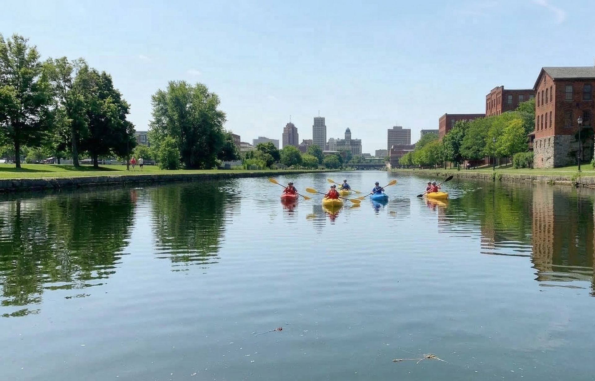 Group of kayakers paddling through an urban canal with city skyline